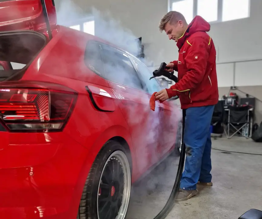 Handarbeit bei der Fahrzeugaufbereitung im Sauerland – Reinigung mit dem Dampfreiniger in der Halle von Siebers