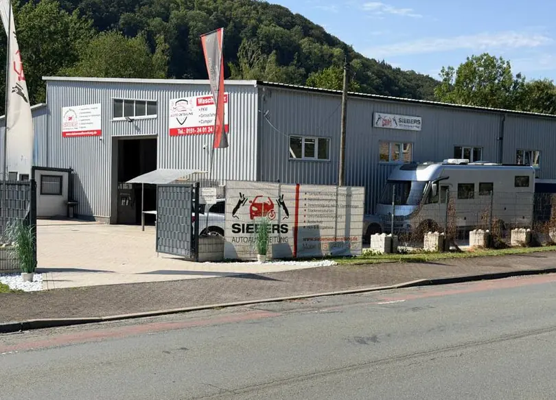 Betriebsgelände der KFZ-Aufbereitung Siebers in Marsberg-Bredelar mit Halle und Einfahrt – Fahrzeugaufbereitung im Sauerland