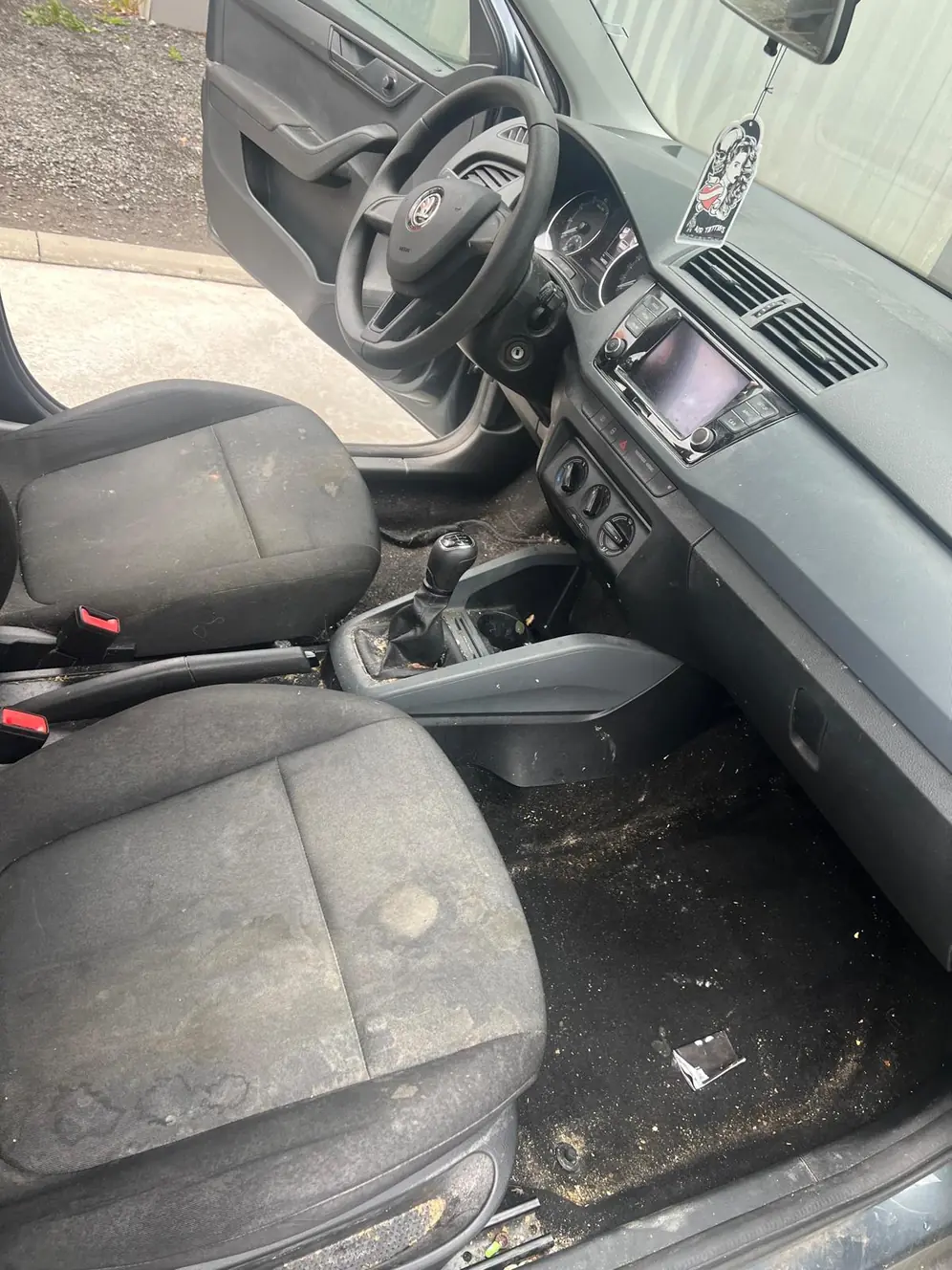 Škoda Fabia vor der Aufbereitung, Blick durch die Beifahrertür auf den verschmutzten Fußraum – KFZ-Aufbereitung Siebers