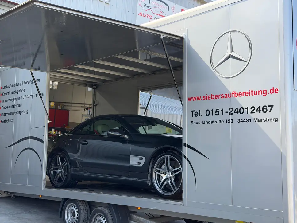 Geschlossener Transportanhänger der KFZ-Aufbereitung Siebers mit beladenem Fahrzeug