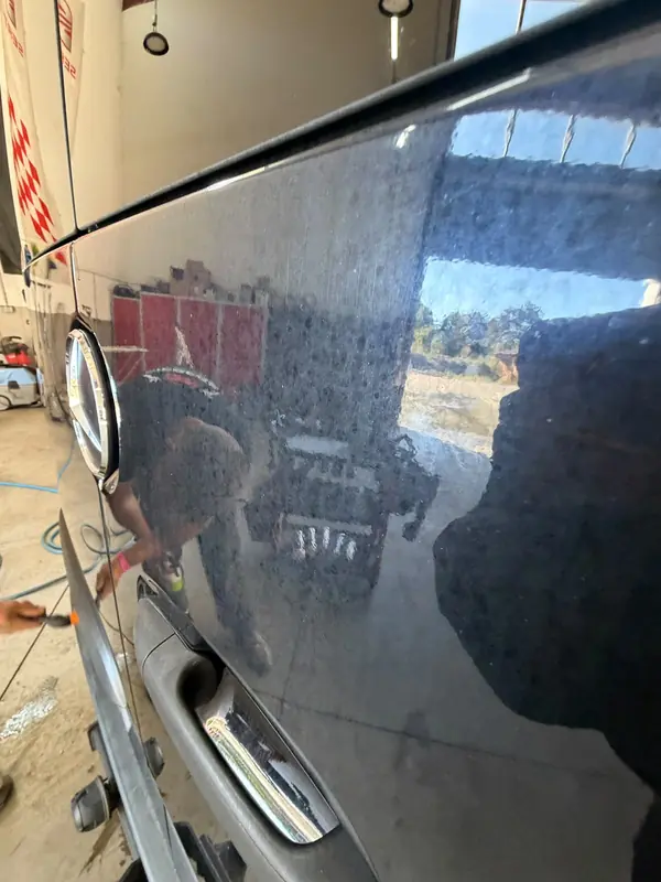 Schiebetür des Mercedes Sprinter vor der Aufbereitung, schwarzer Lack mit eingetrockneten Wasserflecken – Siebers KFZ-Reinigung und Pflege