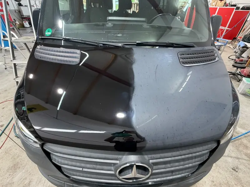 Motorhaube des Mercedes Sprinter nach der Politur, klare Lichtreflexe statt matter Fläche – Siebers KFZ-Reinigung und Pflege